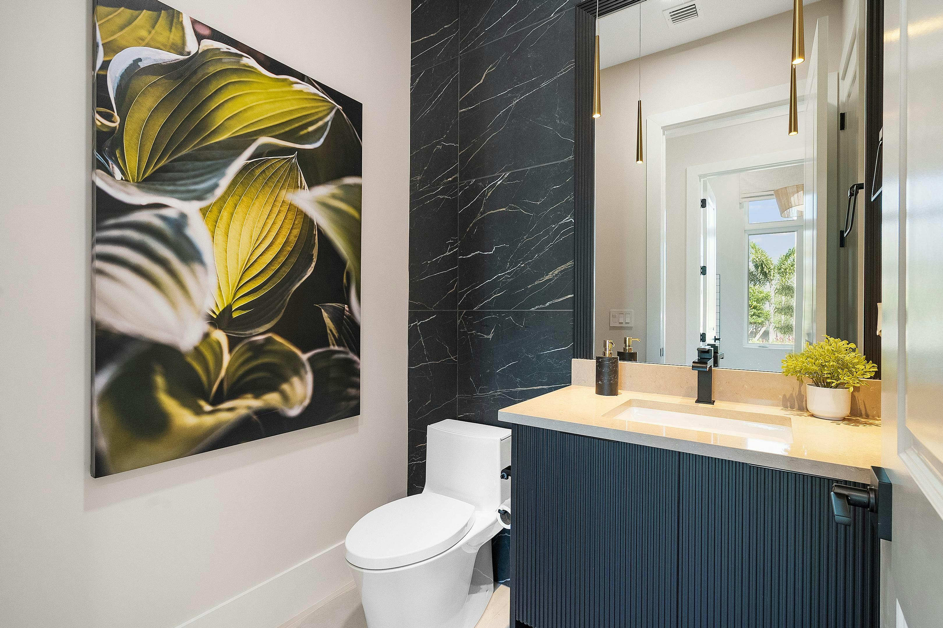 Powder bath with black tile wall details and blue cabinets modern look