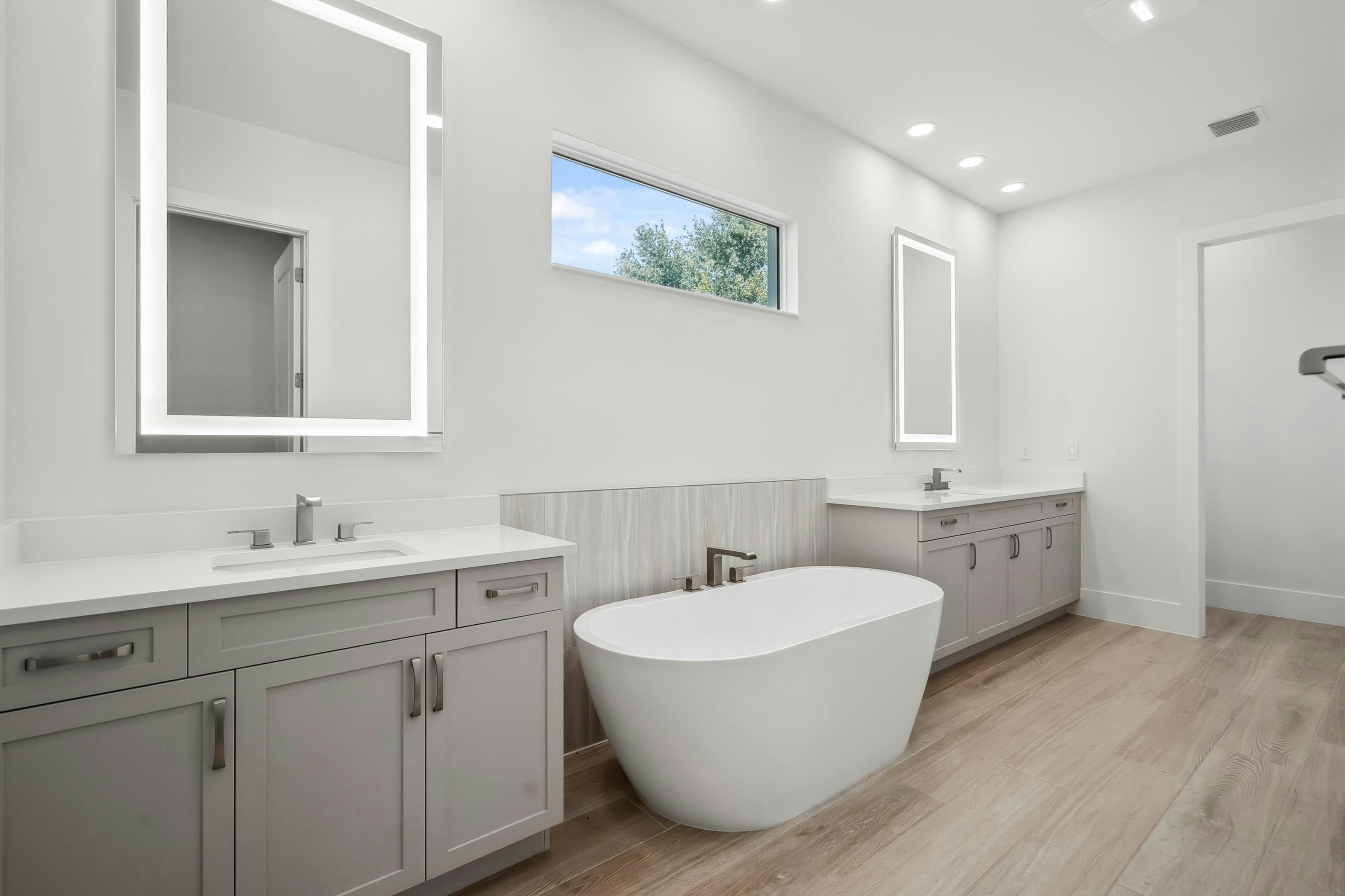 Master bath with oval tub between split vanity