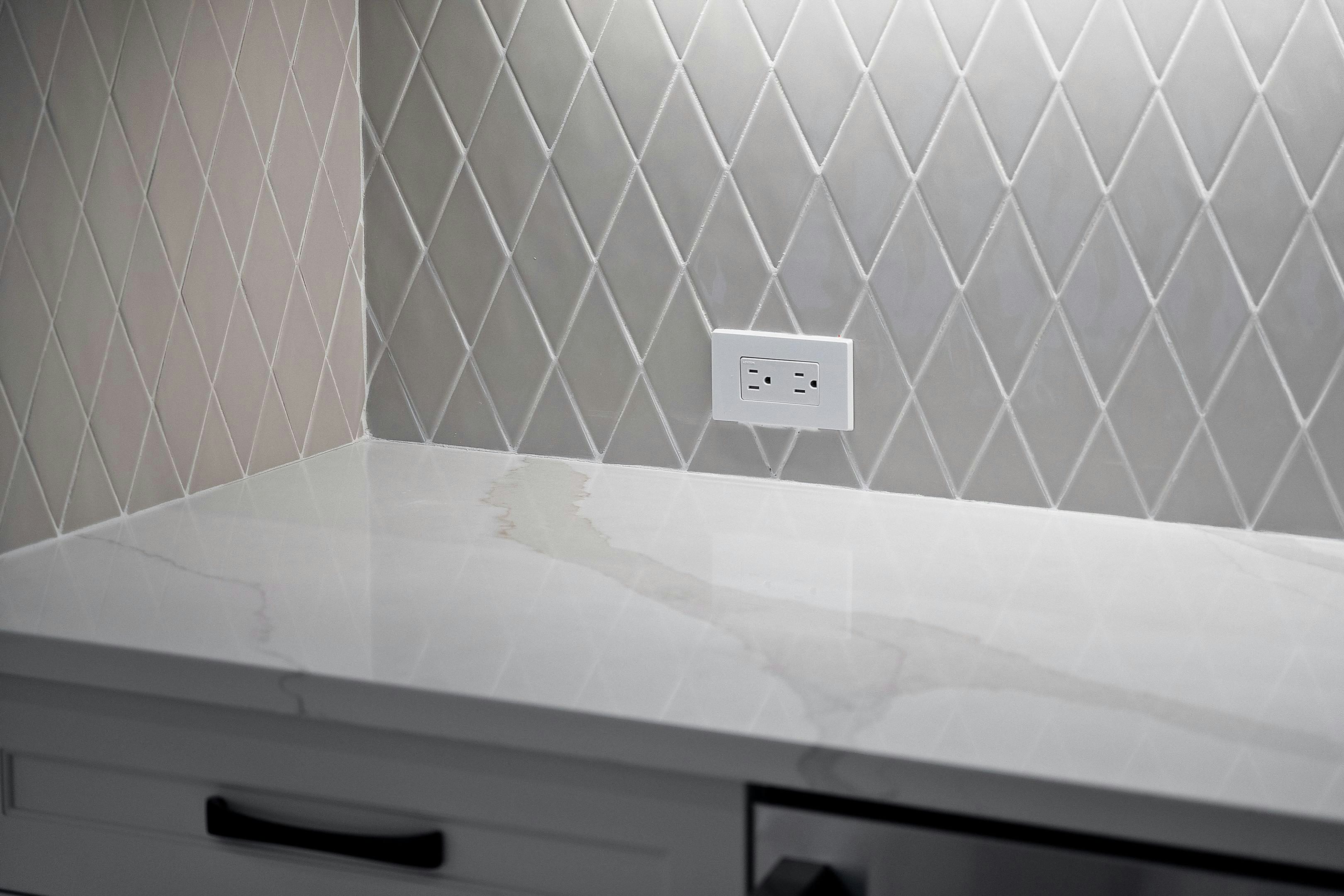 Tiled diamond shaped grey backsplash & white & grey countertop | Stella TES 23