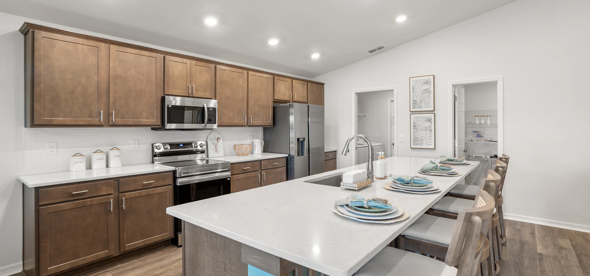 Kitchen with wood cabinets and quartz counters in a brand-new Lakeland model home