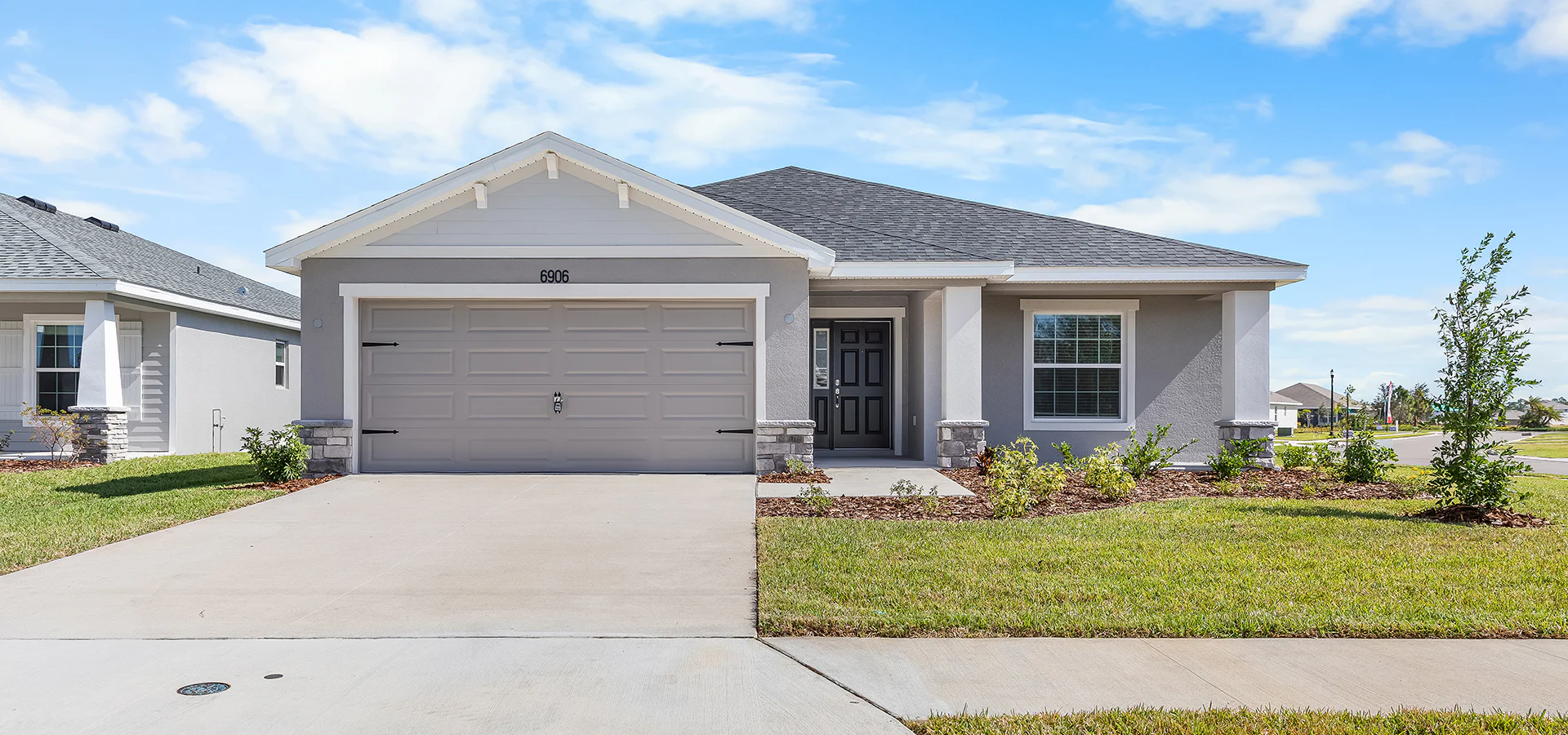 Exterior of the Raychel by Highland Homes with stone accents and a classic-columned front porch