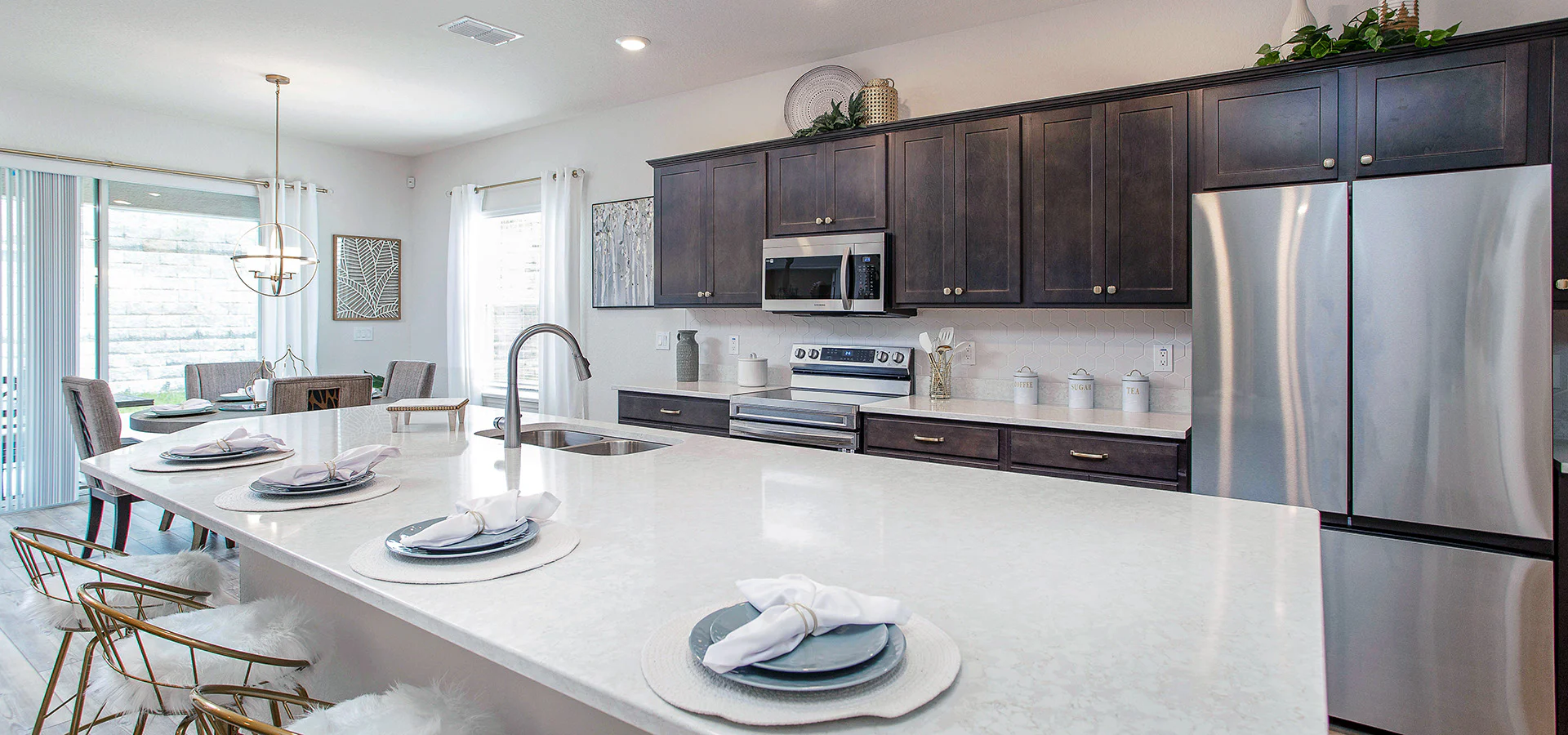 Open kitchen with a large island, quartz counters, and rustic wood cabinets