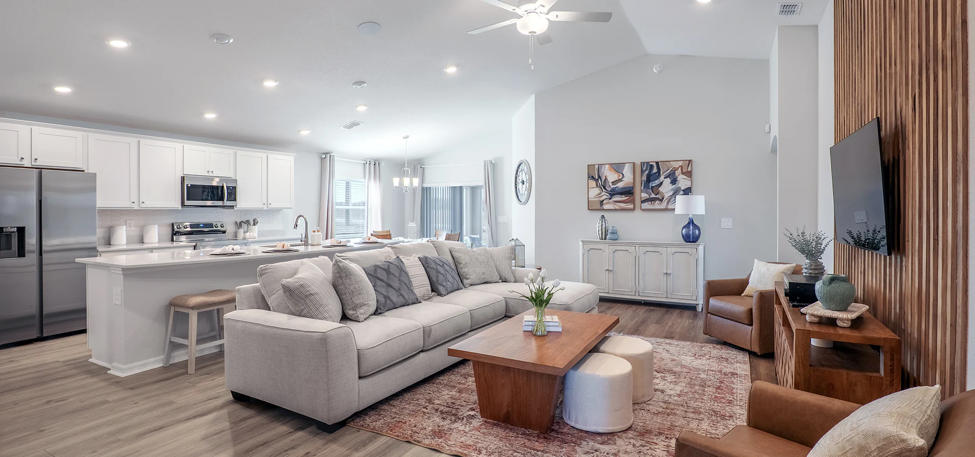 Open living area with volume ceilings, wood and white finishes.