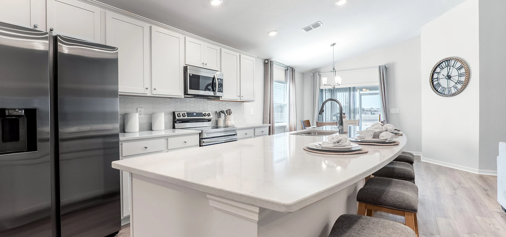 Bright kitchen with white cabinets and a large island with quartz counters