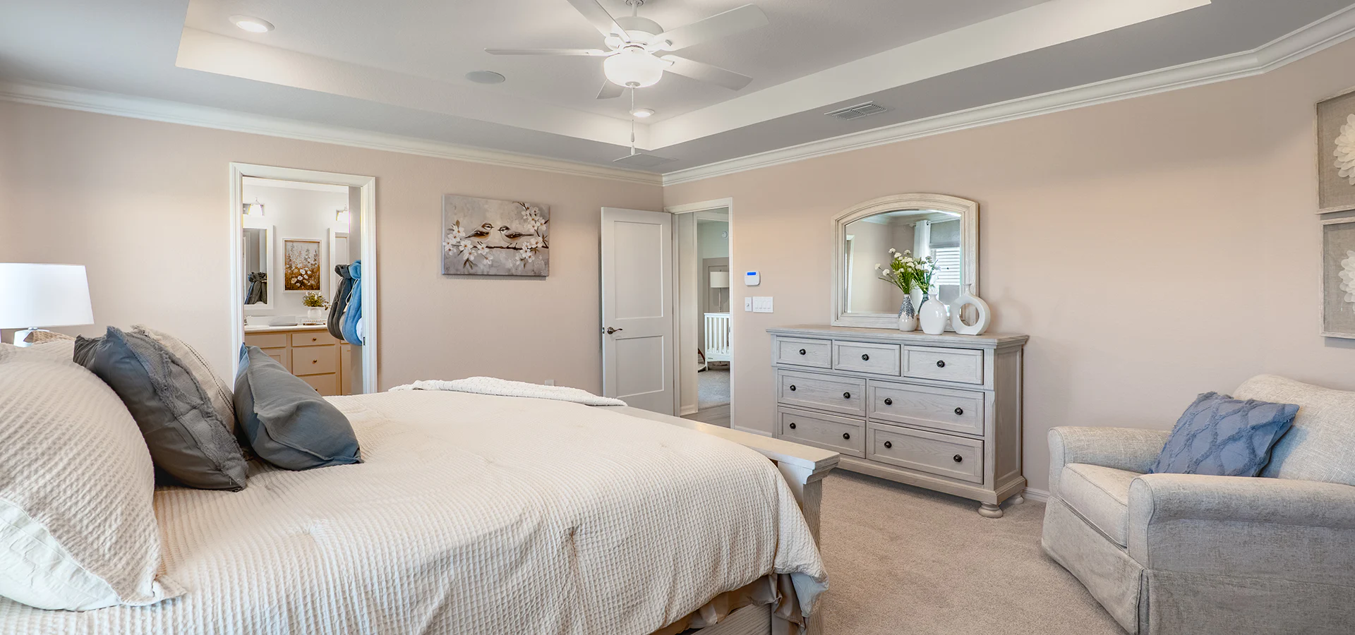 Large bedroom with a king sized bed and overstuffed armchair.
