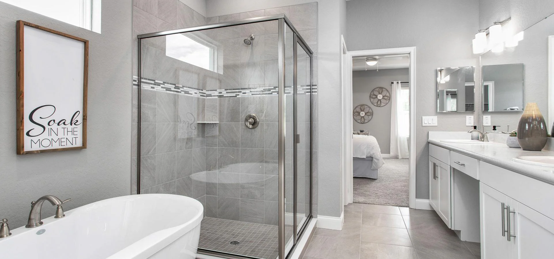 Private en-suite bath with dual vanities and tiled shower with optional freestanding tub in the Waylyn, a new home plan by Highland Homes