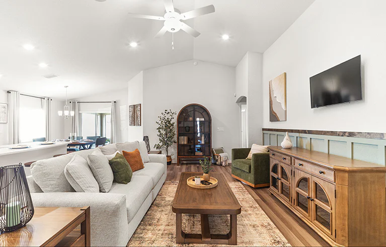 Living area in the Raychel by Highland Homes, with LVP flooring, overstuffed furniture, and midcentury style accents.