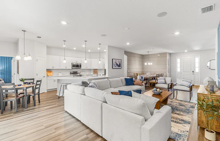 Open living area in the Westin II by Highland Homes in Wildwood, decorated with neutral and blue tones.